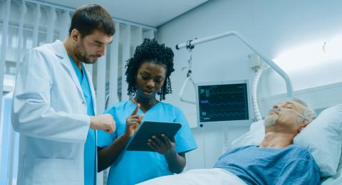 Nurse Practitioner and doctor working with patient at bedisde