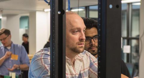 People gathered around a Dell computer at the IOL