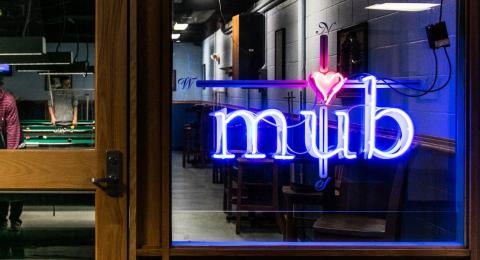 Photo from outside of the MUB game room with neon MUB sign