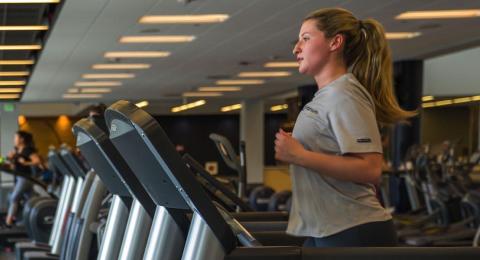 student running on treadmill at campus rec center