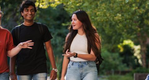 Group of students talking while walking on campus