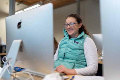 Woman looking at computer smiling