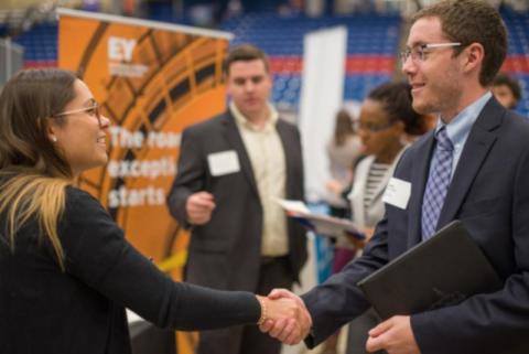 two people shaking hands at conference
