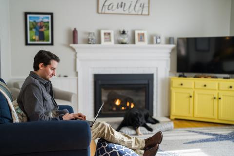 Man sitting at home on the sofa working on laptop