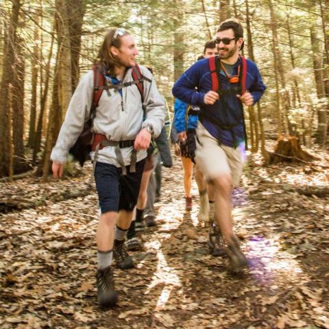 students hiking through College Woods in the fall