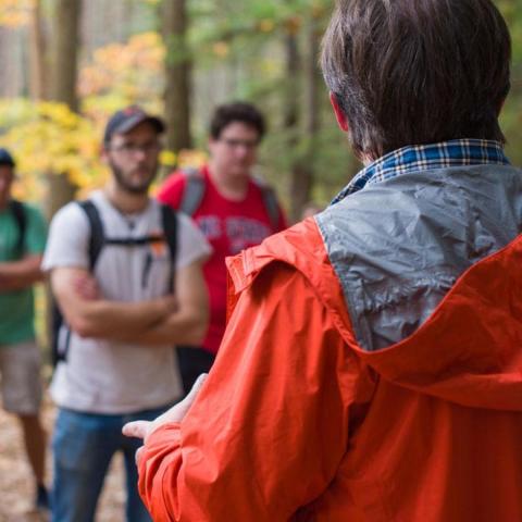 Professor talking to students while on walk through College Woods