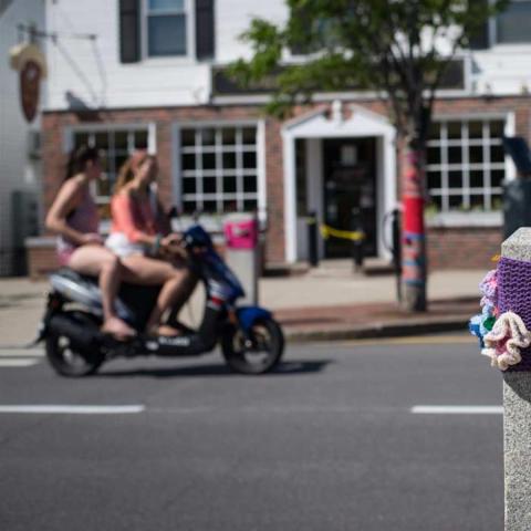 Students riding a moped through downtown Durham