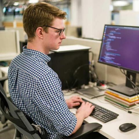 Student sitting at desk working on computer