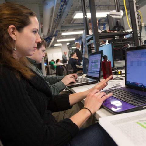 Students typing on computer during Plugfest