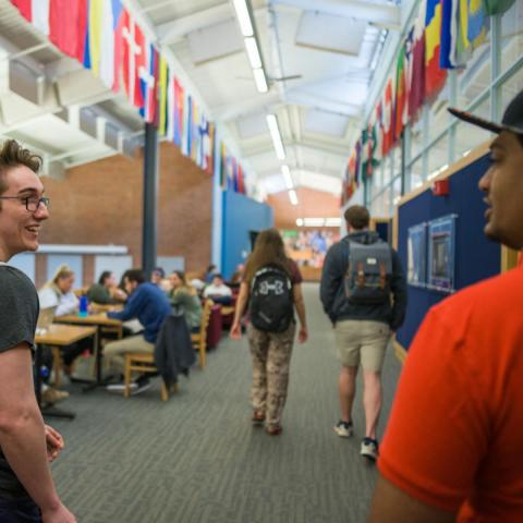 Students walking down flag lined hall in the MUB