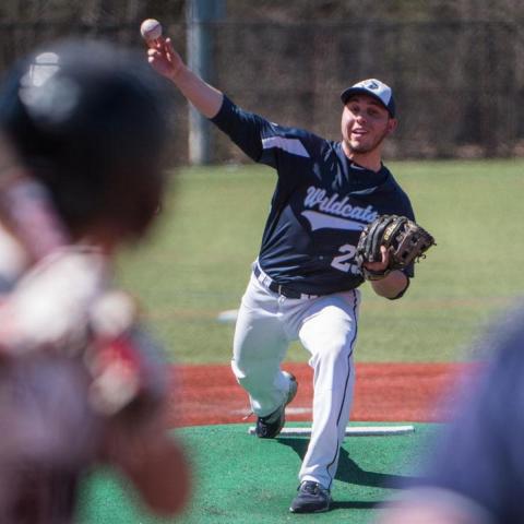 Student throwing a baseball in club baseball game