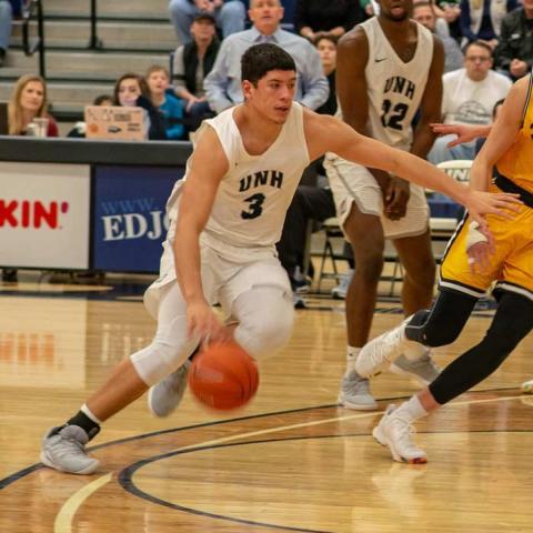 UNH basketball player dribbling a basketball