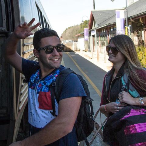 Students boarding the amtrak and waving goodbye