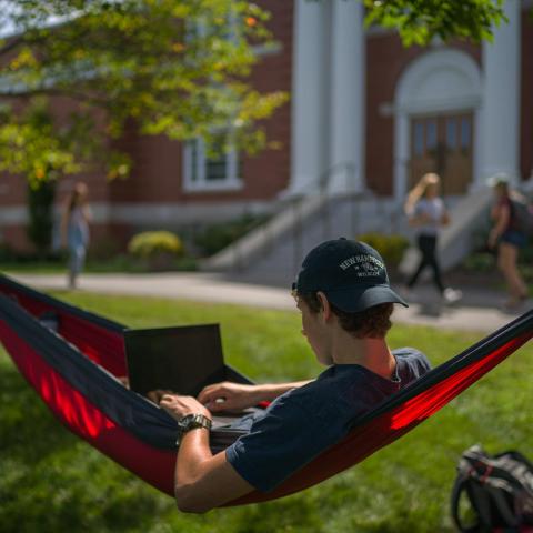 UNH student relaxing in hammock